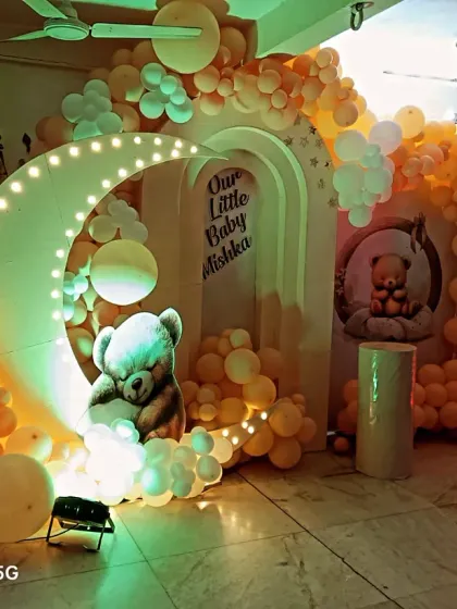 A warm-toned version of the moon and teddy bear theme for baby Mishka. The yellow and orange lighting gives the entire setup a cozy, sunset-like glow, perfect for an evening celebration.