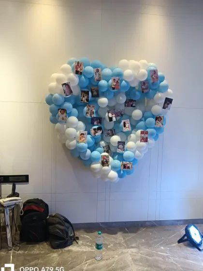 A heart-shaped balloon wall created with blue and white balloons. This unique installation was used as a photo collage board, allowing the family to display precious pictures of their little one.
