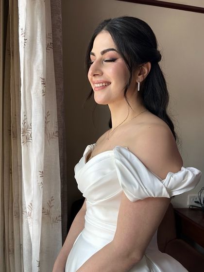 A happy, smiling moment. The makeup uses soft brown and pink tones to enhance her natural beauty for a fresh and timeless Christian bridal look.