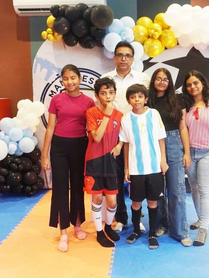 The birthday boy and his friends pose for a photo in front of the impressive football-themed backdrop.