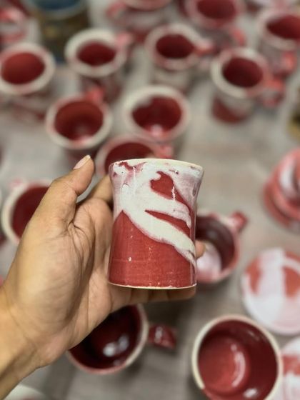 Holding a small cup from the Flamingo series. The abstract pattern is reminiscent of a flamingo's feathers.