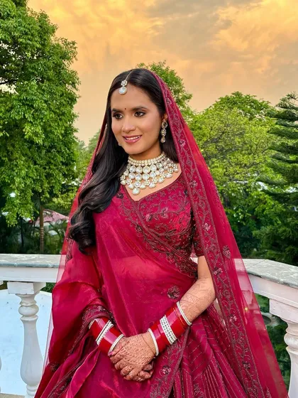 A full-length shot of this bride in her deep red lehenga. The entire look is a perfect blend of tradition and modern elegance.
