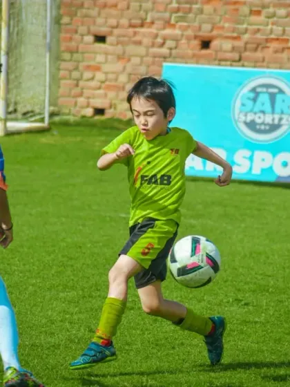 A player skillfully controls the ball mid-air, fending off a defender in a display of advanced technique.