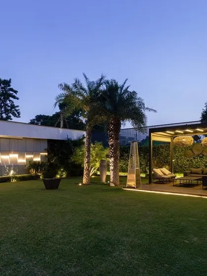 A duplicate of image 31, this photo highlights the sophisticated lighting scheme that transforms a simple lawn into a luxurious nighttime landscape. The illuminated pergola and feature wall provide both ambiance and functionality.