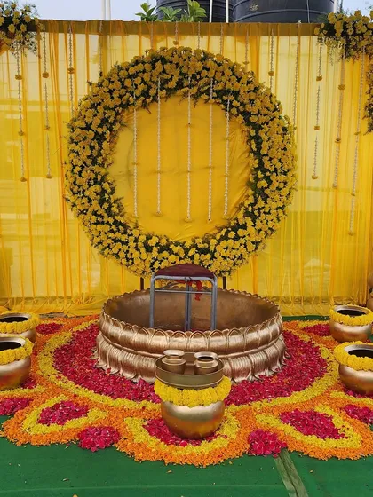 A Haldi ceremony should be full of joy and vibrant color. I created this beautiful outdoor setup using marigold flower arrangements, a traditional brass *urli* for the ceremony, and a bright yellow backdrop to make the photos look stunning.