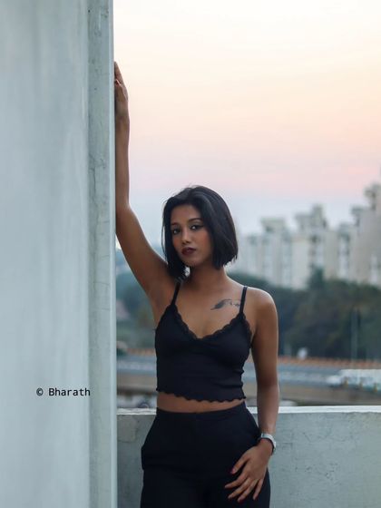 A full-length portrait on a rooftop, using the last light of the day to create a dramatic and modern urban scene.