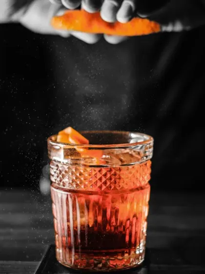A cocktail should be a work of art. Here, we are finishing a classic with a spritz of orange zest, a final touch that awakens the senses and sets the tone for the evening.