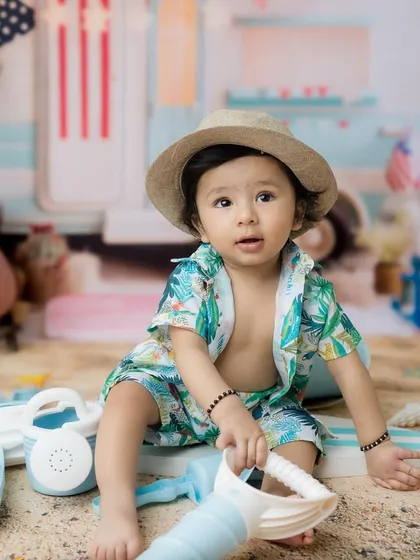 Exploring the toys and props during his fun, beach-themed toddler photoshoot.