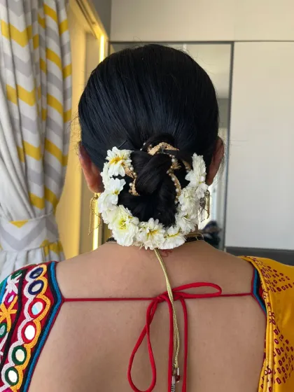 A traditional bridal bun for a Mandava Murat ceremony, elegantly decorated with fresh white flowers. This is a classic look for the mother of the groom.