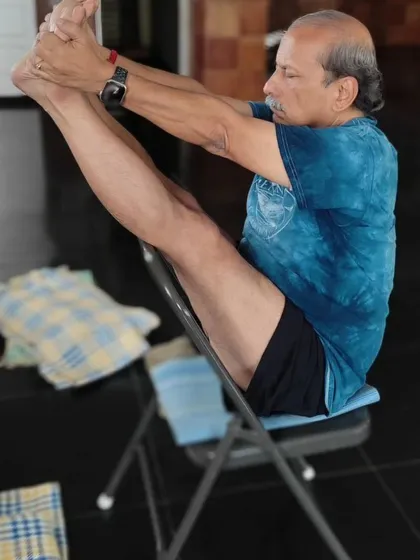 A variation of Navasana (Boat Pose) on a chair.