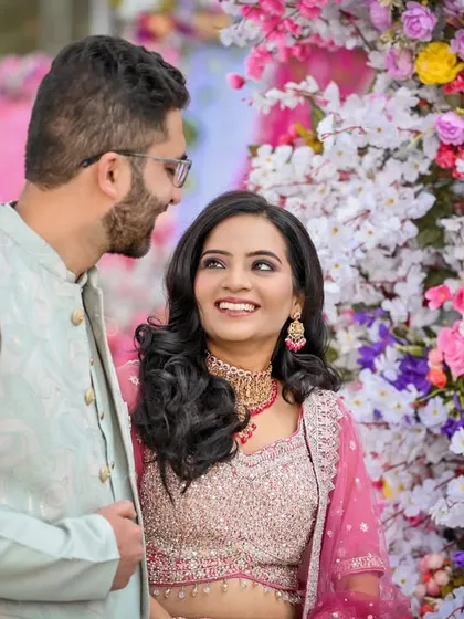 The couple sharing a look amidst a vibrant floral backdrop, a perfect capture of their engagement day bliss.