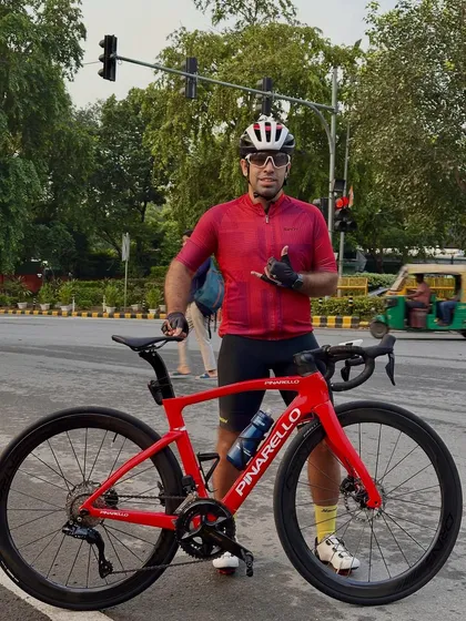 Geared up and ready to ride. A member of our team poses with his high performance Pinarello road bike, showcasing the serious equipment we use to chase our competitive goals.