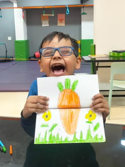 The pure joy of creation. This little artist is so proud of his surprise carrot and bunny drawing, a perfect example of the fun and imaginative art projects we do in our creative sessions.