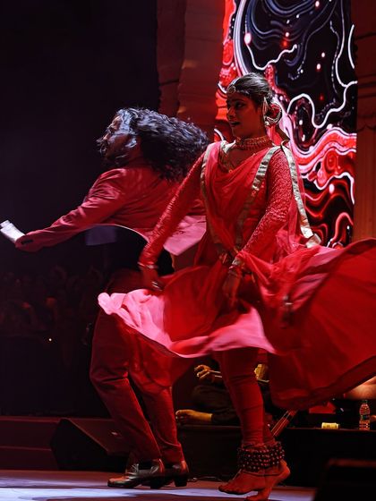The beautiful swirl of red costumes during a high-energy Flamenco-Kathak performance.