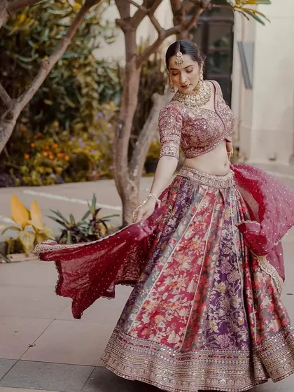 We love outfits that tell a story, like this multi-colored floral lehenga. The rich fabric and flowing skirt create a beautiful silhouette in motion, making it a picturesque choice for any pre-wedding event or a daytime wedding.