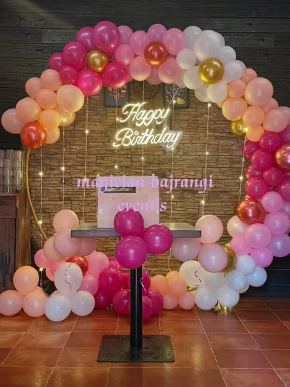 A full view of the elegant ring backdrop with a cake table, perfect for a birthday or anniversary celebration.