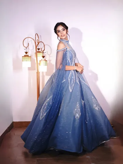 This Cinderella-blue gown with cape sleeves is straight out of a fairytale. The silver embellishments add a touch of magic.