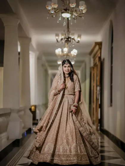 A full-length portrait of the beautiful Walima bride, her golden lehenga shining in the elegant corridor.