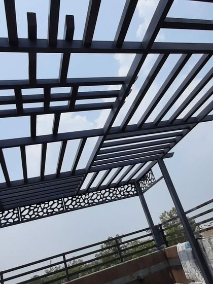 The combination of the geometric roof and the pebble-patterned CNC panels gives this pergola a unique and contemporary look.