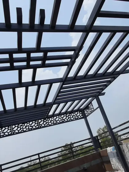 The combination of the geometric roof and the pebble-patterned CNC panels gives this pergola a unique and contemporary look.