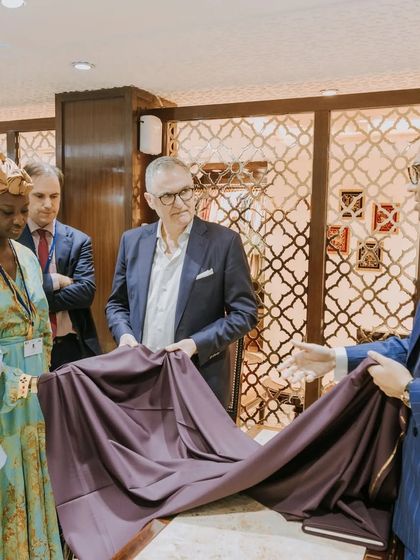 A moment of decision during a fabric consultation. We are showcasing a luxurious purple cloth to our esteemed guests from the Belgium Trade Commission, demonstrating the drape and feel that cannot be appreciated from a swatch alone.