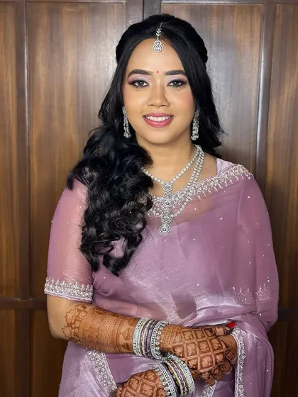 A beautiful portrait of this bride in a lavender saree for her reception, her makeup glamorous and her smile radiant.