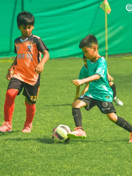 A young GSC player dribbles past a Fast FC opponent in a U-9 match.