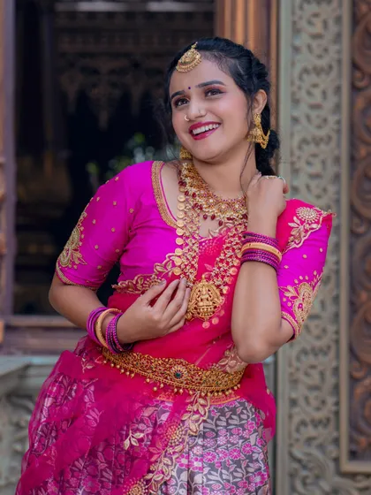 A joyful, smiling shot of the model in the pink half-saree.