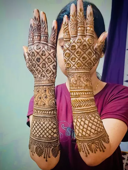 A classic engagement look with full-coverage jaali (net) patterns on the back of the hands, extending up the arms.