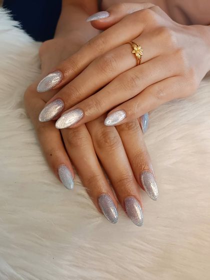 Icy and sparkling cat eye nails that look like they're dusted with snow.