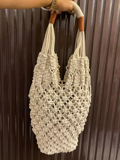 This is my full macrame net-style tote bag, a perfect companion for a trip to the market. It's lightweight, expandable, and has sturdy, comfortable handles.