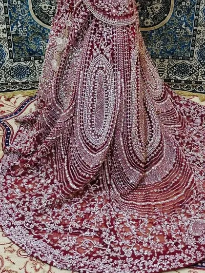 A detailed shot of the flare and intricate silver embroidery on a Pakistani-style maroon bridal lehenga. This highlights the craftsmanship of the outfits I offer.