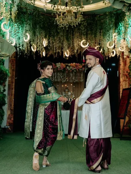 The couple walking hand-in-hand, a perfect picture of togetherness. The bride's Nauvari saree looks stunning as she walks.