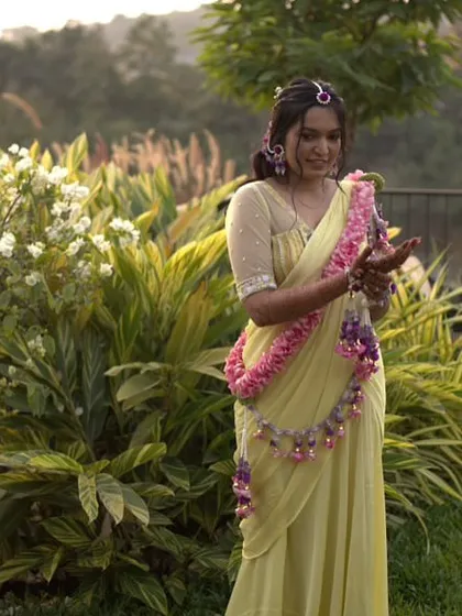 The bride enjoying the outdoor setting of her Haldi. Our fresh floral jewellery, including the garland and hair accessories, looks beautiful in the natural light.