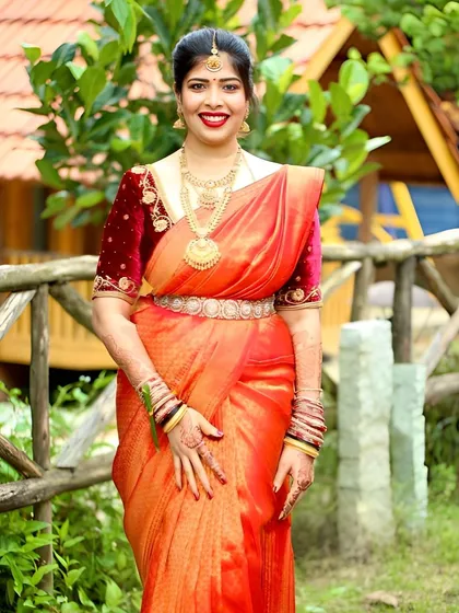 My forever favorite client looking radiant in a custom-made velvet blouse. The rich maroon velvet is embroidered with delicate gold threadwork, perfectly complementing her vibrant orange Kanchipuram saree.