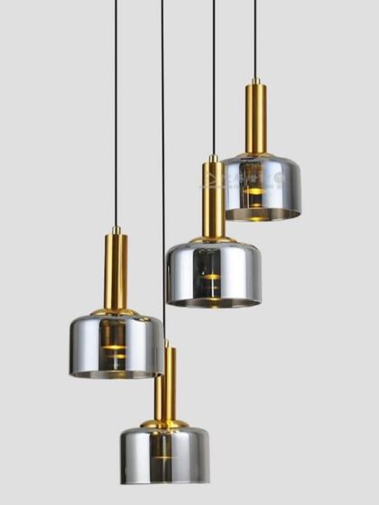 A cluster of four pendant lights with smoked glass shades and brass fittings, perfect for a kitchen island.