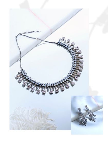 A stylized shot of the black rhodium set, showing the necklace and earrings separately to emphasize their individual design and unmistakable presence.