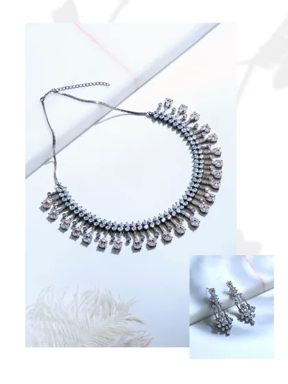 A stylized shot of the black rhodium set, showing the necklace and earrings separately to emphasize their individual design and unmistakable presence.
