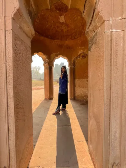 The play of light and shadow in this corridor creates long, dramatic lines, beautifully framing the model in the distance. It's a very atmospheric and artistic shot.