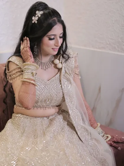 Golden vibes for this engagement night. The bride is glowing in a beautiful golden lehenga, with glittery eyes and a chic high ponytail.