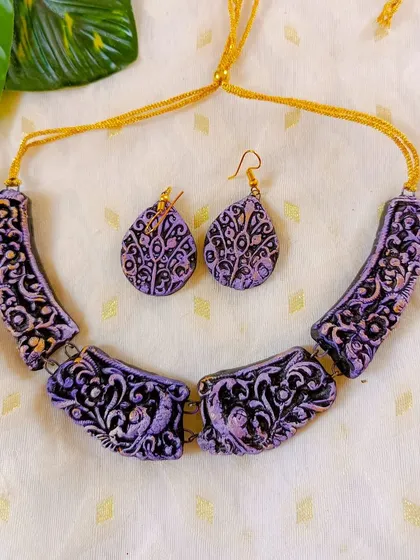 I love the elegance of a 'hansli' necklace. This one features intricate, hand-carved details with a beautiful lavender finish, paired with matching teardrop earrings.