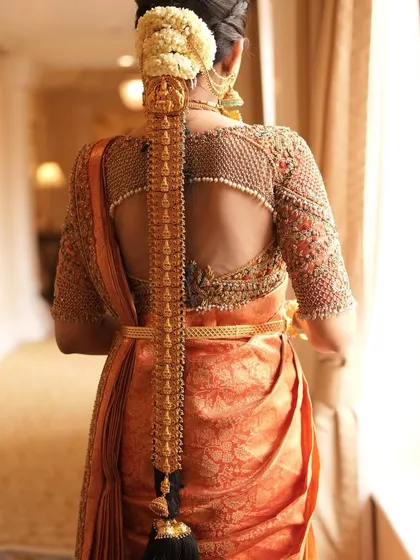 The back of a blouse is just as important as the front. This design features a sheer back with intricate pearl and zardozi work, creating a stunning focal point that complements the bride's traditional hairstyle.