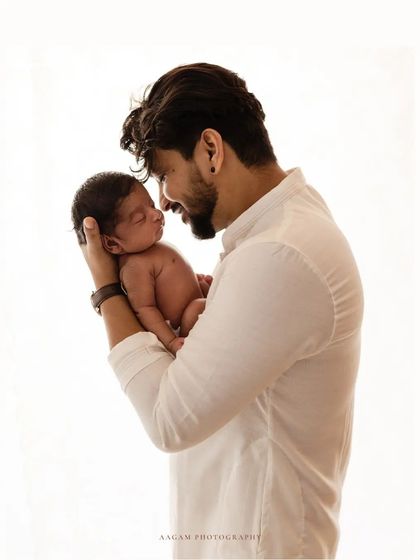 A father's gentle gaze at his newborn. This bright, high-key portrait is full of love and adoration.