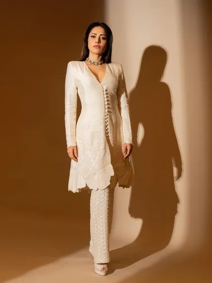 This ivory kurta and flared pants set on Nushrratt Bharuccha is all about classic elegance. The delicate embroidery and button details make it a timeless piece for any special occasion.