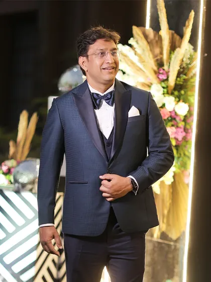 Another look at Mr. Jayesh's deep blue ceremonial tuxedo for his 25th anniversary. The texture of the fabric and the perfect fit of the three-piece ensemble create a look of timeless elegance.
