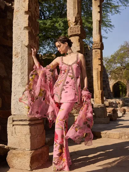 A stunning pink floral co-ord set with flared pants and a sheer, ruffled dupatta, blending modern style with romantic details.