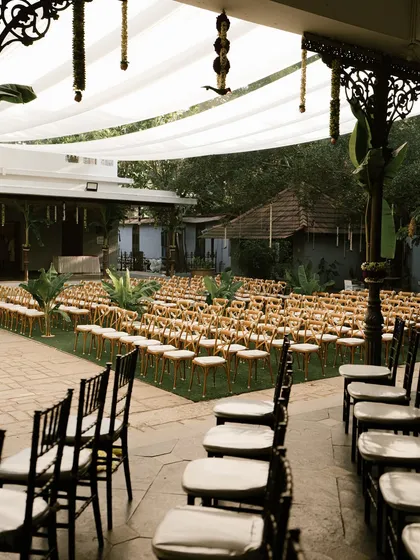 Guest seating arranged on the lawn, with chairs decorated with simple jasmine strings.