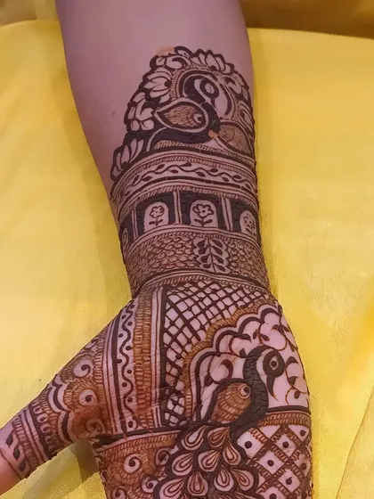 A close-up of a design featuring a peacock inside a jharokha (window), a classic element of Rajasthani mehendi art.