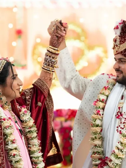 A triumphant and joyful moment as the couple raises their joined hands after a wedding ritual.