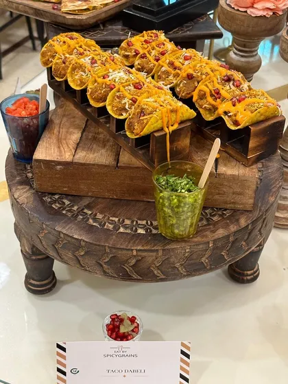 We love to innovate with fusion flavors. Our Taco Dabeli is a perfect example, combining the zesty crunch of a taco with the sweet and spicy potato filling of a classic Indian street food. It's a unique, bite sized delight for any festive table.